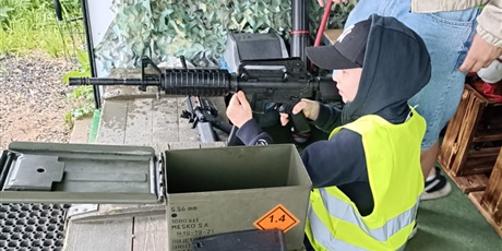 Powiększ grafikę: Uczeń strzela z karabinu do celu.