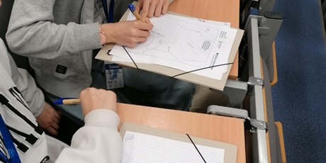 Powiększ grafikę: Uczniowie robią notatki.